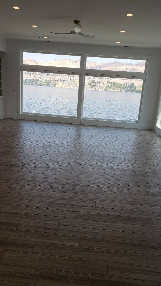Wood-look tile flooring in a great room with lake view installed by River Rock Flooring