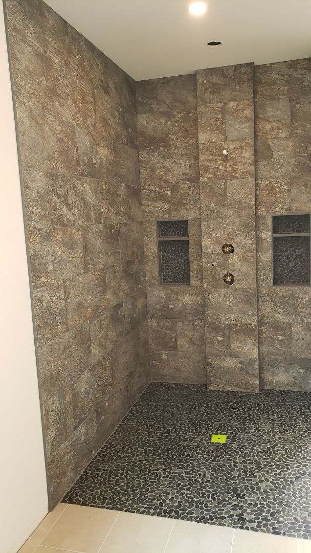 Rustic stone tile walk-in shower with black pebble floor in Wenatchee WA